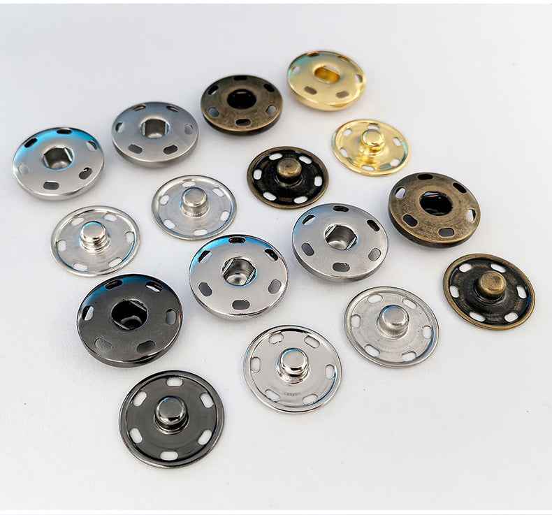 Assorted metal snap fasteners with round faces in silver, black, bronze, and gold tones
