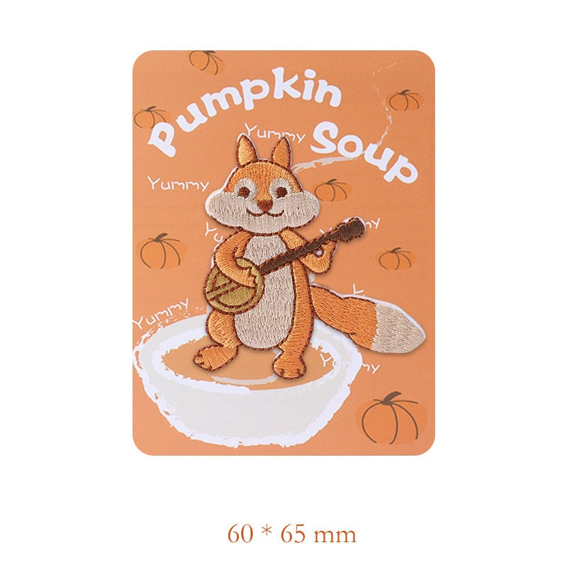 Embroidered squirrel patch playing guitar, orange-brown body with light tail