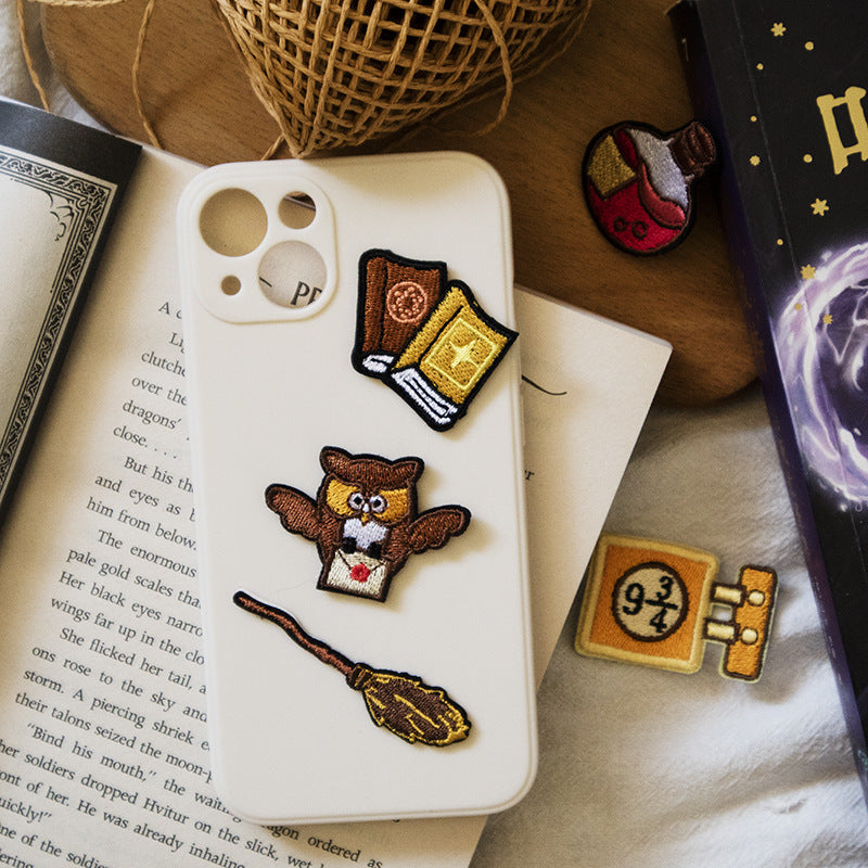 Self-adhesive embroidered patches with brown owl, yellow book, and wand