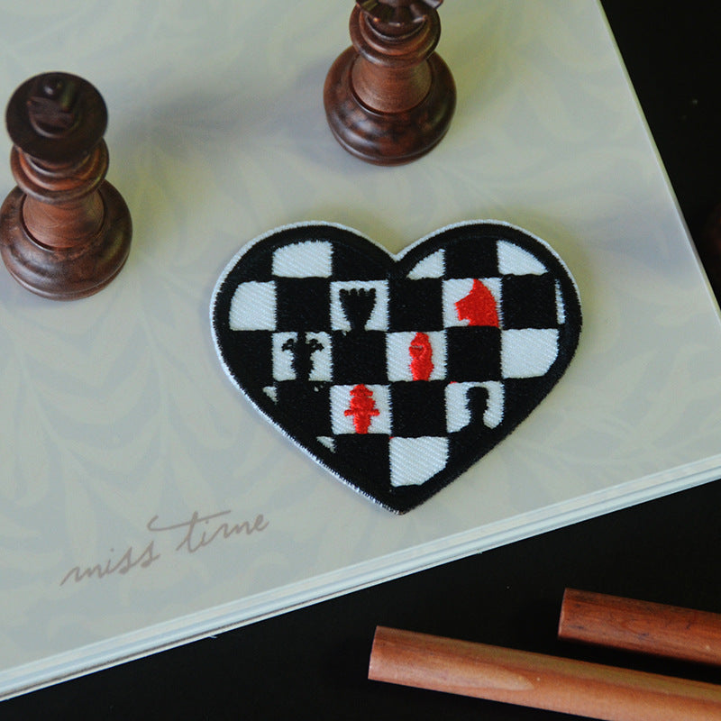 Heart-shaped embroidered patch, black and white checkerboard with red king details