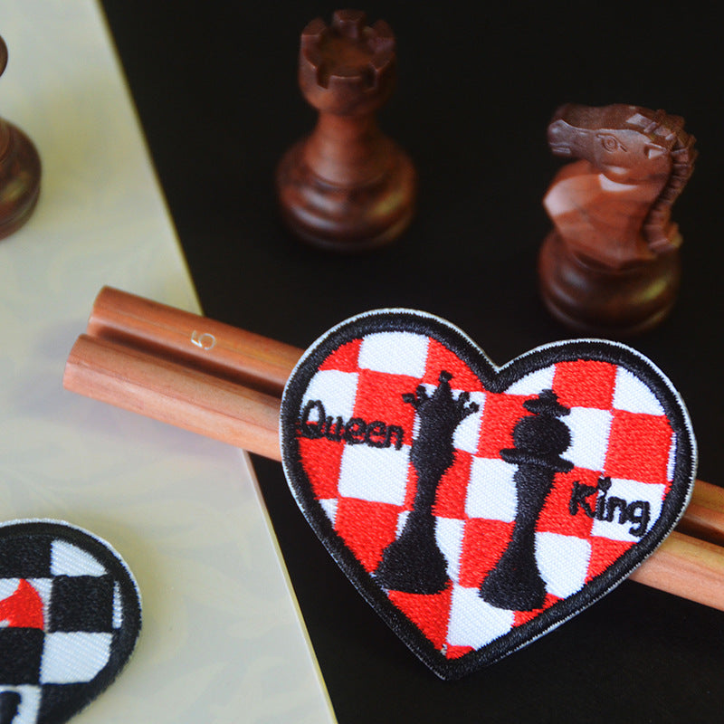 Heart patch with red/white checkered design and black chess king silhouette, stitched
