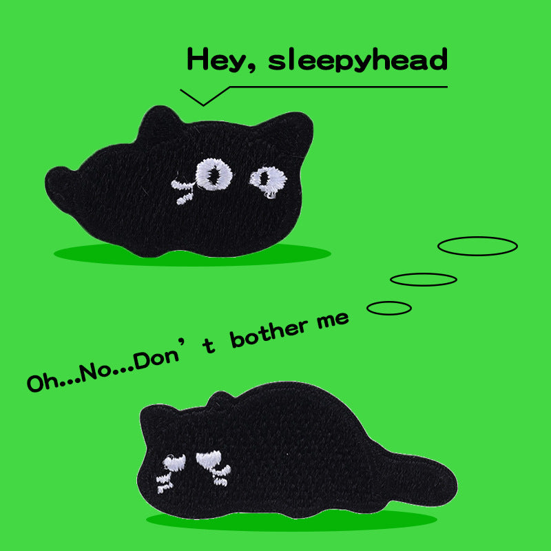 Two embroidered black cat patches, one lying down and one sleeping curl, white details