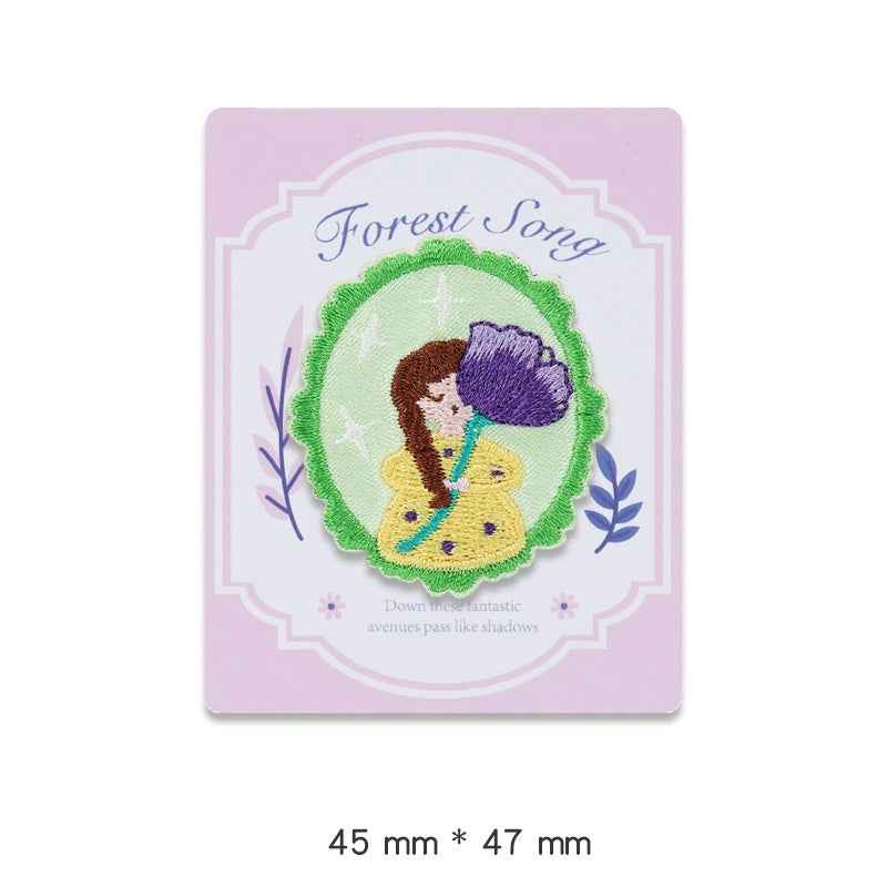 Forest Song embroidered adhesive patch: green circular scene with bird and yellow flowers