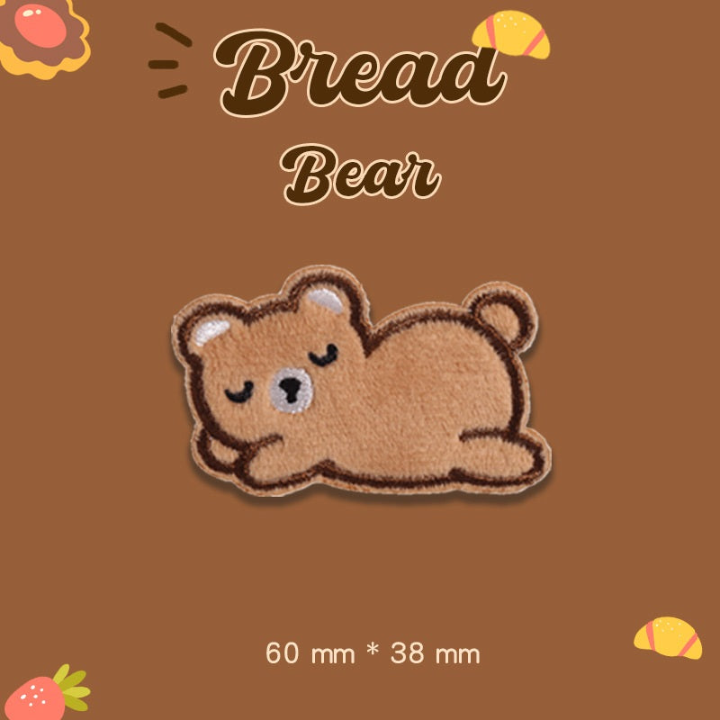 Tan plush bear embroidered patch lying down, 60 mm x 38 mm