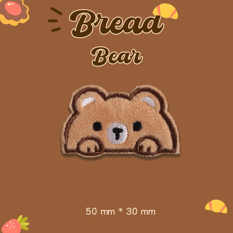 Tan plush bear embroidered patch lying down, paws visible, 50 mm x 30 mm