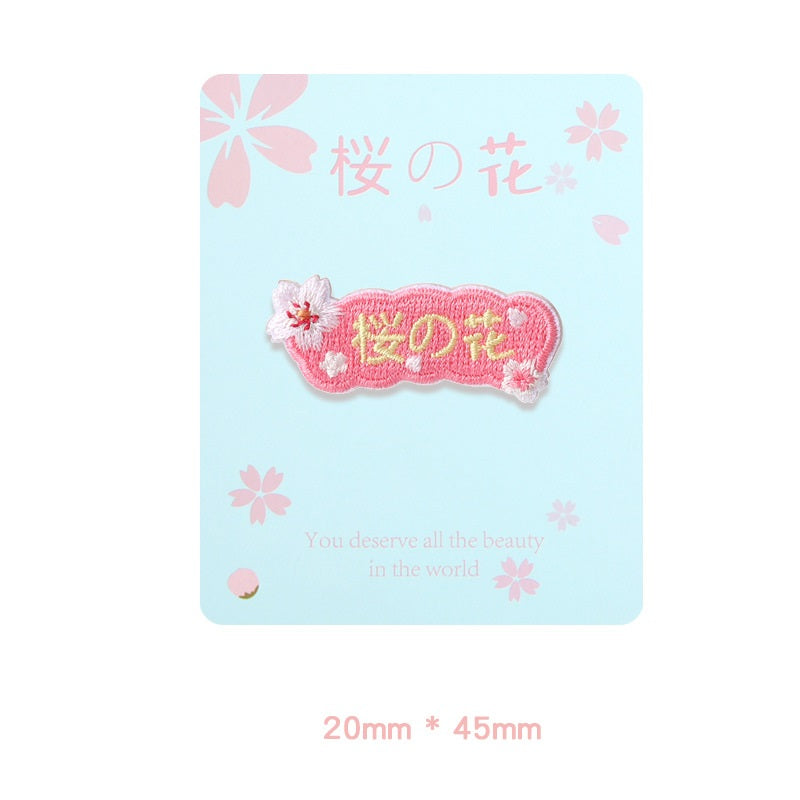 Pink “sakura” embroidered self-adhesive patch with small flower accents