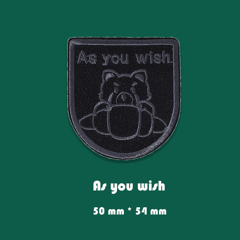 Black embroidered self-adhesive shield patch, 'As you wish' text, 50x54 mm