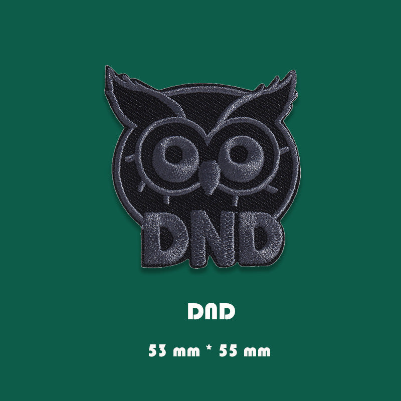 Black embroidered DnD owl badge patch with outlined owl face and bold DnD lettering