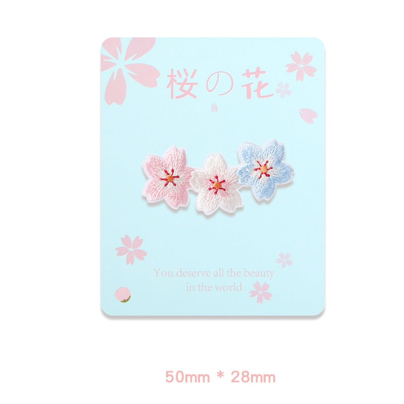 Three sakura flower embroidered self-adhesive patches in pink and blue