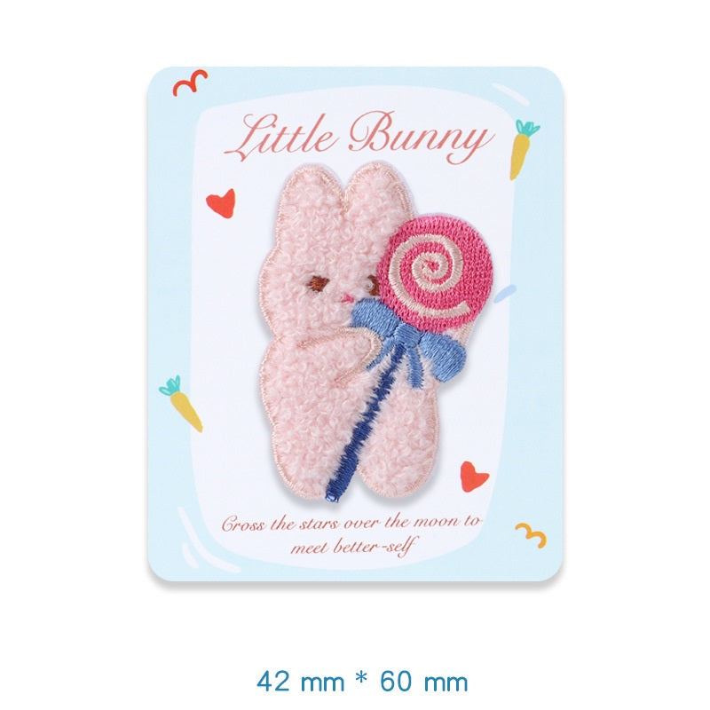 Pink plush bunny embroidered adhesive patch, holding a pink swirled lollipop