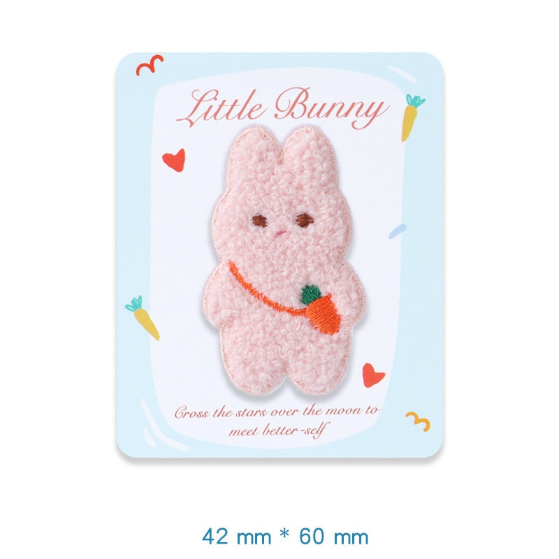 Pink plush bunny embroidered adhesive patch, holding an orange carrot