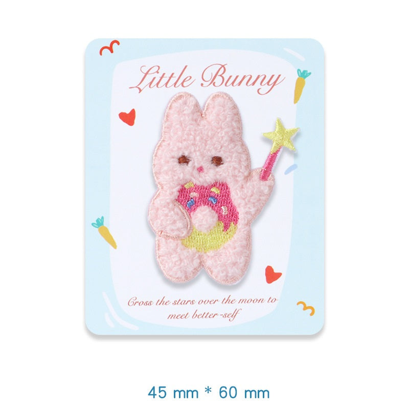 Pink plush bunny embroidered adhesive patch, holding a rainbow wand with star