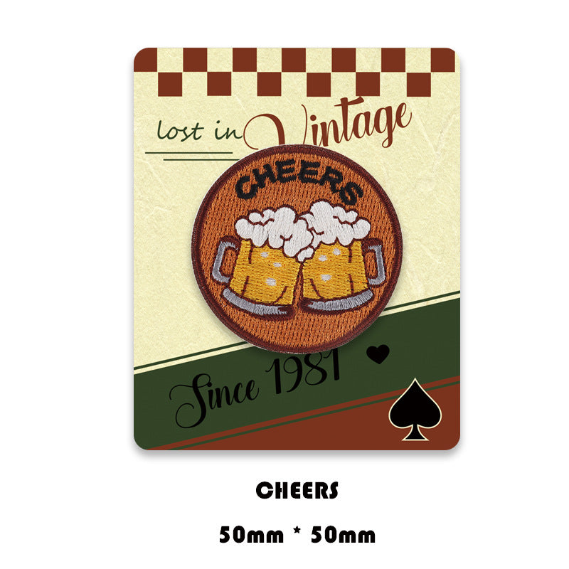 Cheers beer mugs embroidered circular patch in brown and cream tones.