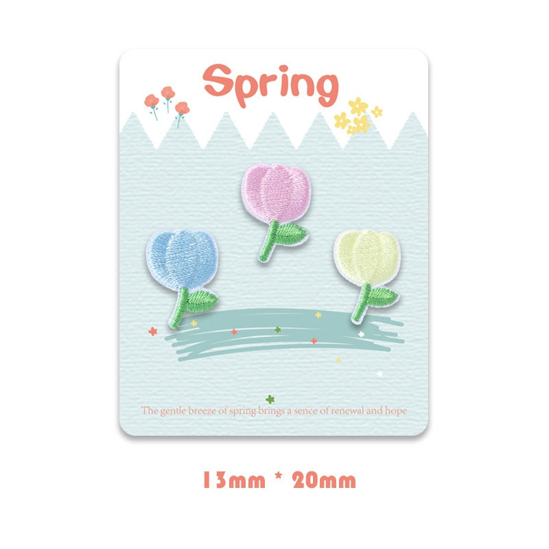 Self-adhesive embroidered blossoms with green stems, pastel blue pink pale yellow, set