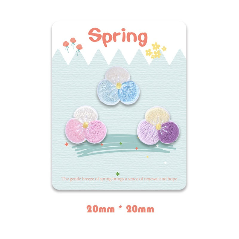 Self-adhesive embroidered flower pair, light blue and pink/purple petals, satin finish