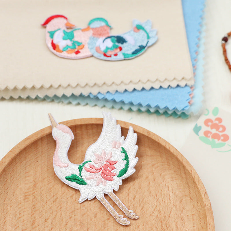 Embroidered white bird patch with pink flower and green leaves, self-adhesive backing