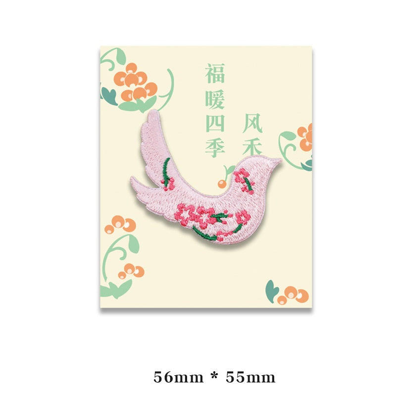 Embroidered pale pink bird patch with red and green accents, self-adhesive backing