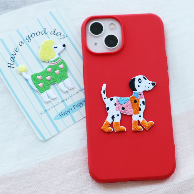 Embroidered dog patch on red case: white spotted dog with orange boots and pink scarf