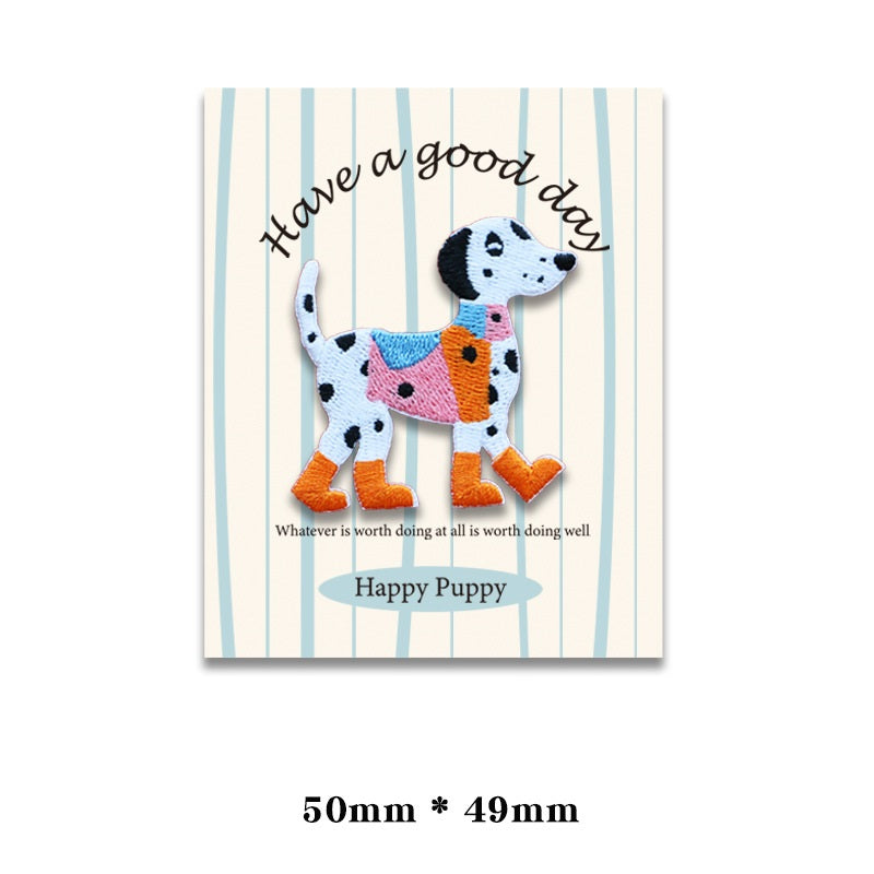 Embroidered dog patch: white spotted dog wearing orange boots, pink vest, and scarf