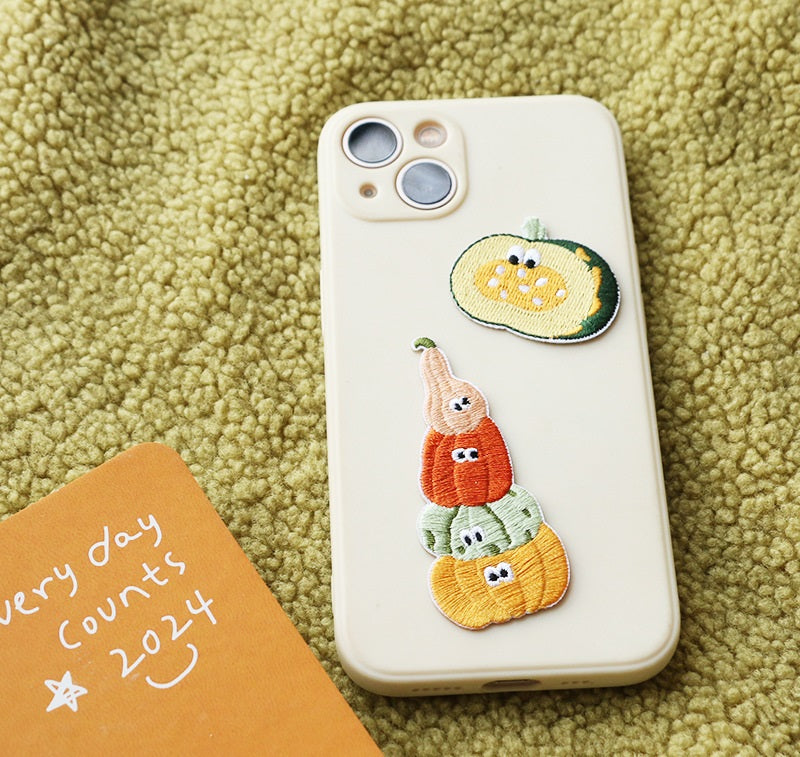 Orange and green pumpkin stack embroidered patch on a phone case