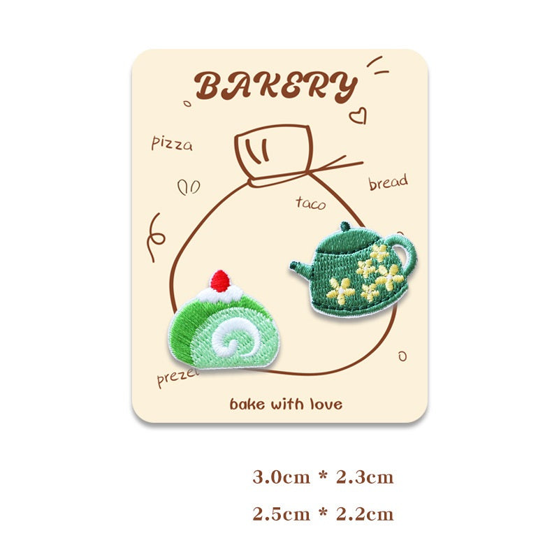 Card showing two mini embroidered baking patches: green Swiss roll and green teapot with flowers.