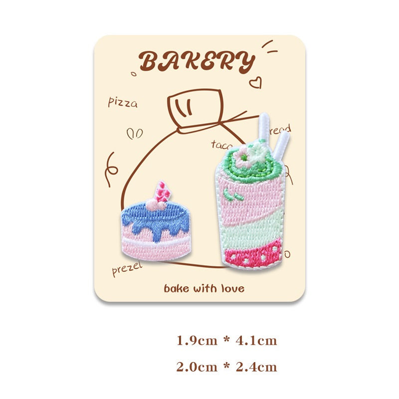 Card with two mini embroidered baking patches: cake slice with candle and pink iced drink.