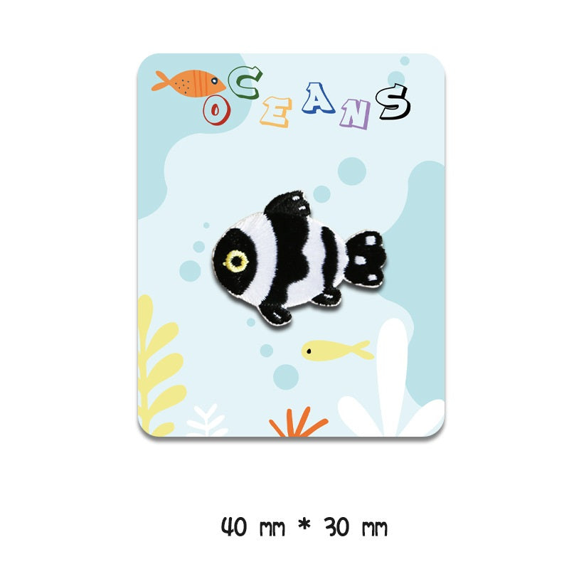Black-and-white clownfish-style embroidered patch with yellow eye, 40 mm x 30 mm