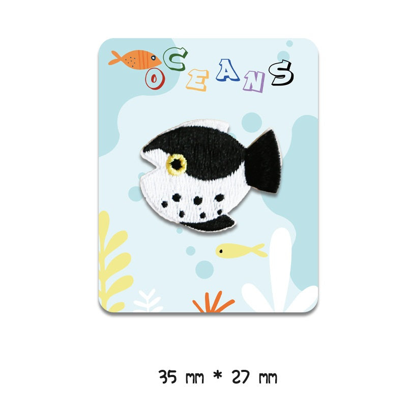 Black-and-white fish embroidered patch with yellow eye and white spots, 35 mm x 27 mm