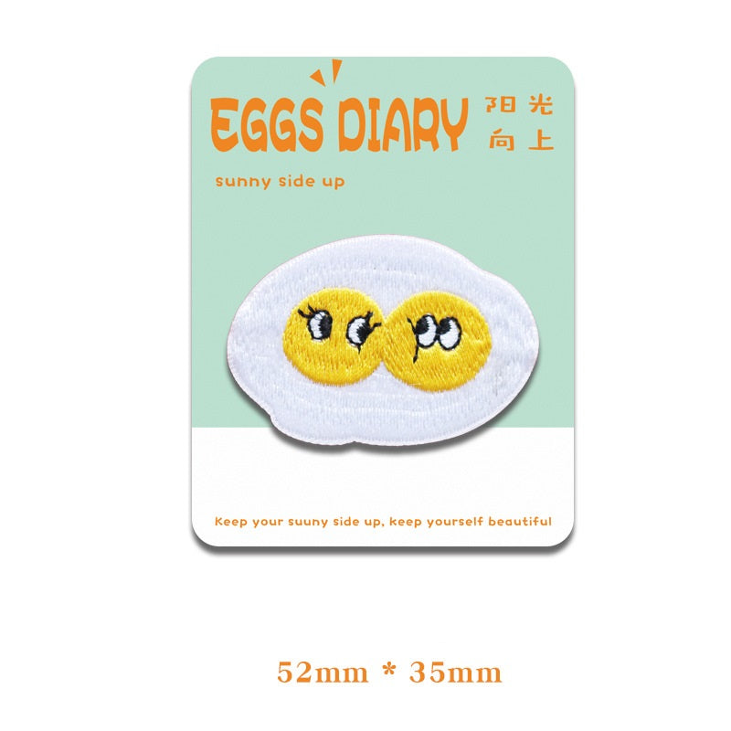 Embroidered fried egg patch with two eyes, hearts and a sleepy expression