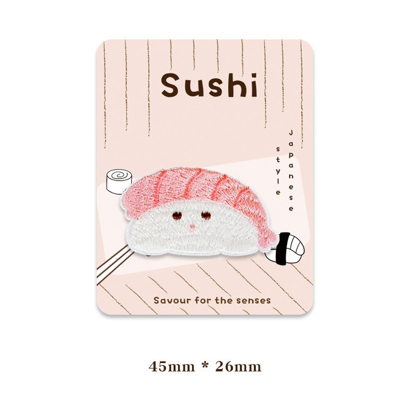 Pink-striped sushi cat patch, white face with brown eyes and small pink whisker stitches