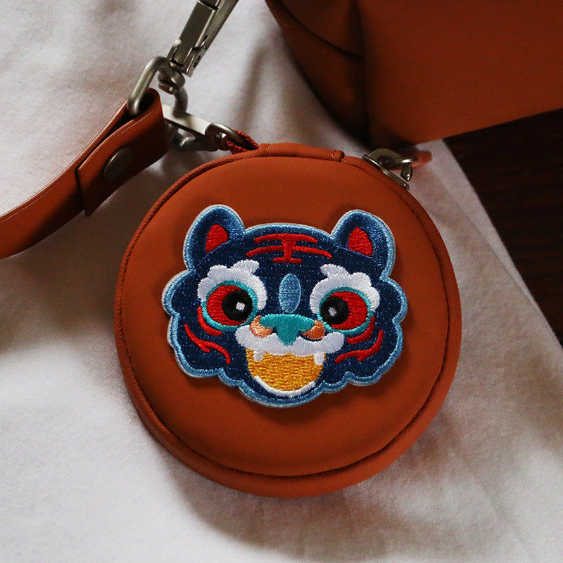 Blue embroidered tiger face patch with red details, green nose, and white whiskers