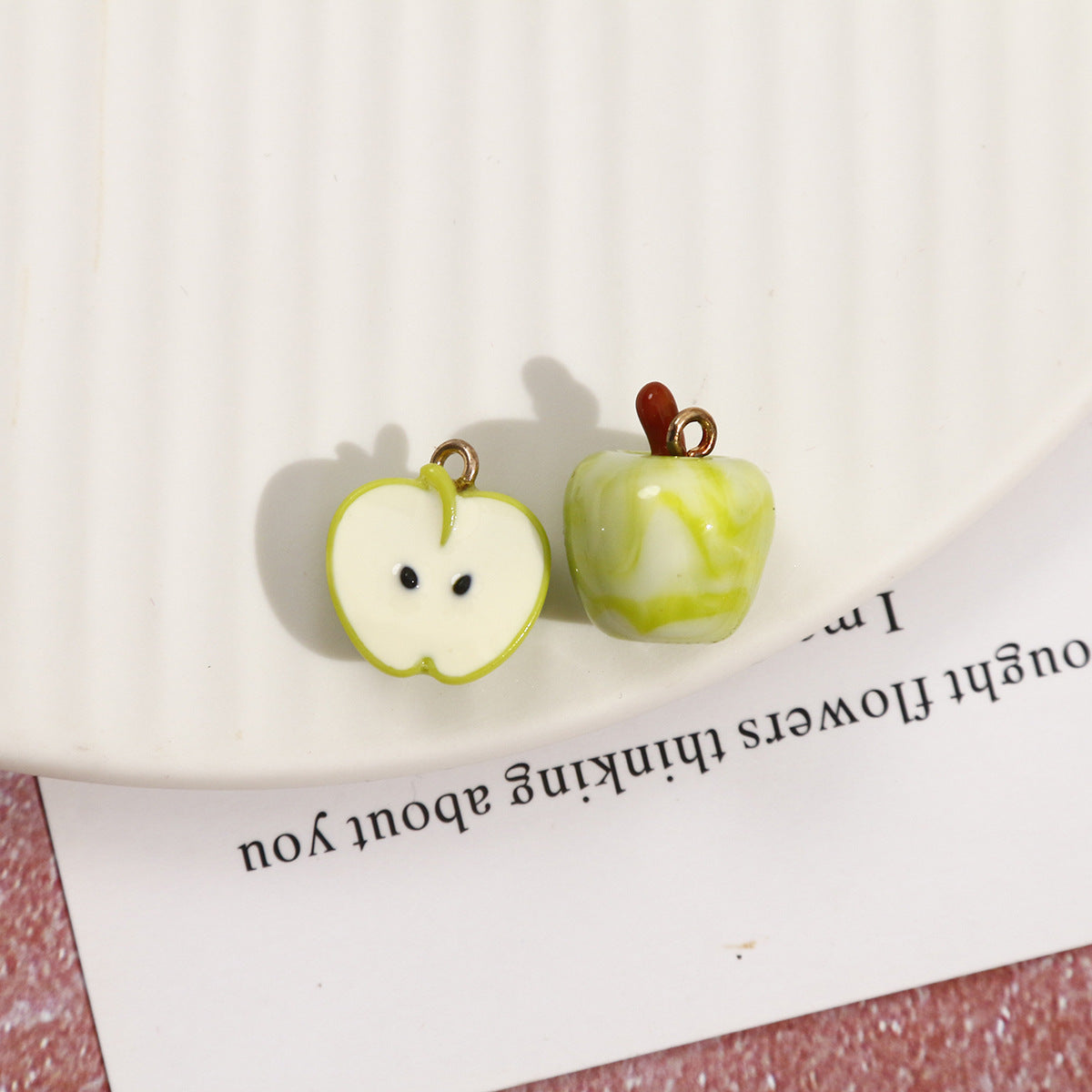 Green apple resin pendants: one cut half with face and one whole apple with stem