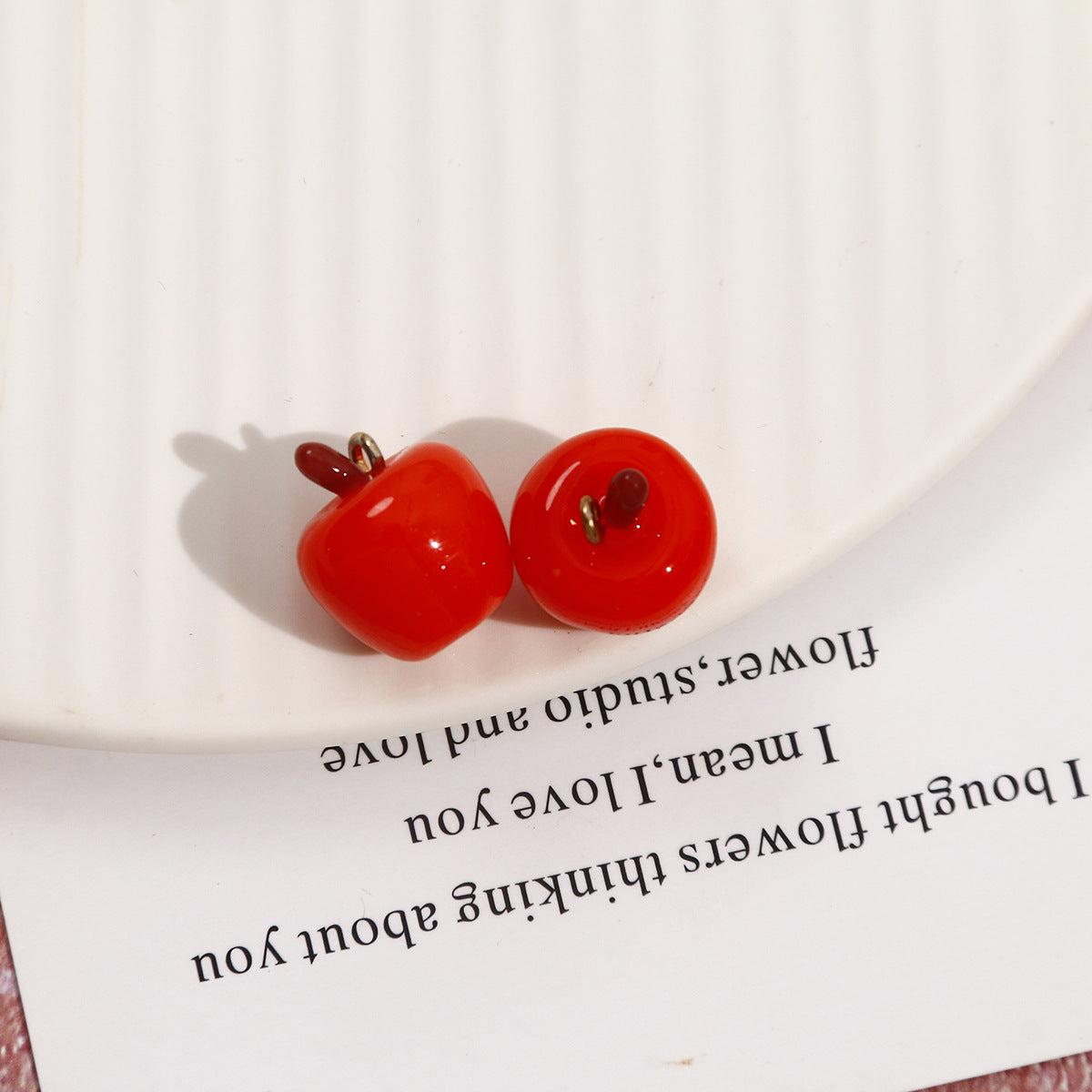 Red whole apple resin pendants, two glossy apples with metal loops and stems