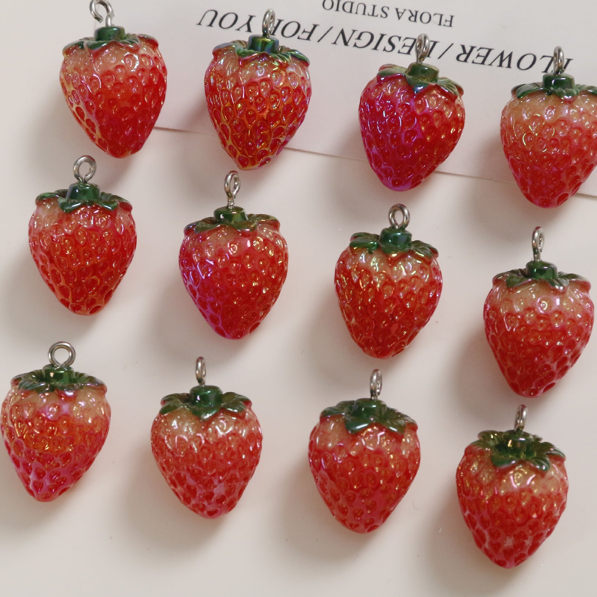 Set of six red resin strawberry pendants with green tops and silver loops